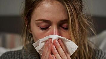 Frau weht ihr Nase mit ein Gewebe sieht aus krank mit rot Augen im ihr Haus video