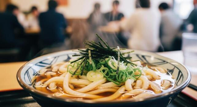 Steaming bowl of udon noodles with green onions and nori seaweed in a japanese restaurant setting photo