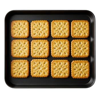 Overhead shot of square crackers neatly arranged on a black baking sheet isolated on white background photo
