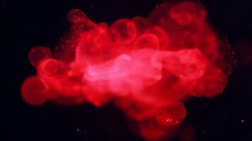 vermelho brilhando blob pulsa e flutua dentro Preto espaço com partículas, fechar acima Visão video