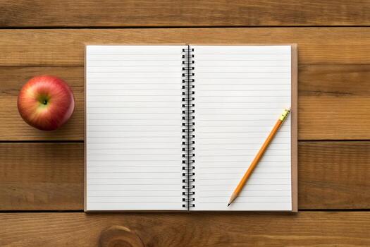 Overhead View of Open Notebook with Apple and Pencil on Rustic Wooden Table photo