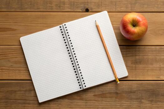 Overhead View of Open Notebook with Pencil and Apple on Rustic Wooden Table photo