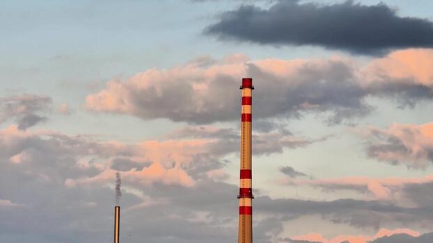 A view of a factory with chimneys and clouds in the background photo