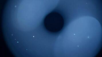 abstrakt blå ljus skapande en mörk cirkulär tomhet med gles ljus partiklar video