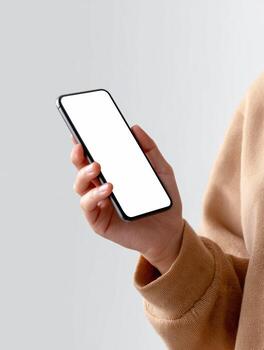Focused person holding smartphone. hand shows phone with blank white screen, perfect mockup for an app or technology concept, illustrating someone using device photo