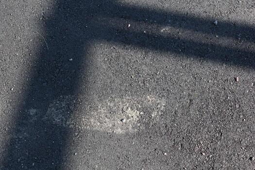 An Abstract Shadow Cast on the Pavement with a Distinctively Textured Surface Design photo