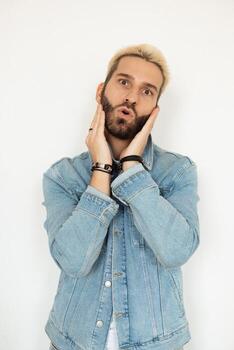 A Surprised Man Posing with a Denim Jacket while Displaying a Playful Expression and Attitude photo