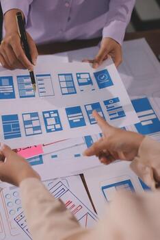 Hands reviewing wireframe designs together photo