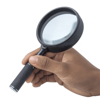 Hand holding black magnifying glass with textured handle, focusing on lens. image highlights tool design and functionality, suggesting investigation or close examination png