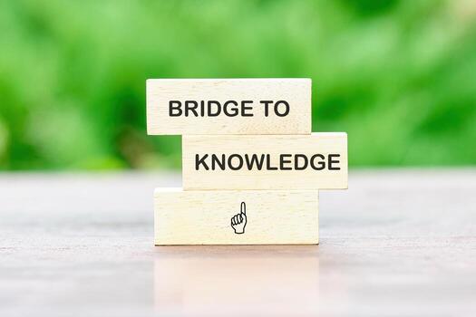 Wooden blocks display the phrase bridge to knowledge, representing the connection between education and business through finance photo
