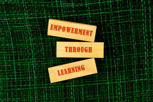 The message connect through learning. EMPOWERMENT THROUGH LEARNING made of wooden blocks on fabric background, top view photo