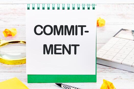 COMMITMENT Word Written on a blank sheet of a desktop notebook photo