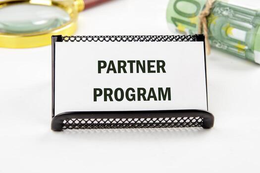 Conceptual partner program symbol. Copy space on a business card on a white background with euro bills and a magnifying glass in the background photo