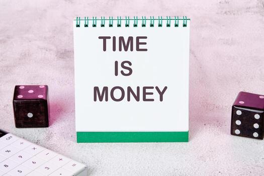 TIME IS MONEY text on a white notepad sheet next to dice on an abstract background photo