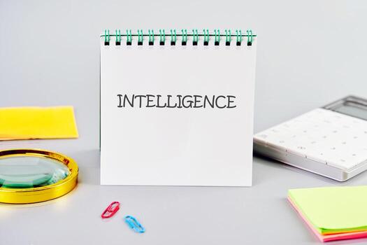 INTELLIGENCE word written in a notebook in a composition with a calculator, a magnifying glass, and stickers. Translation technology concept photo