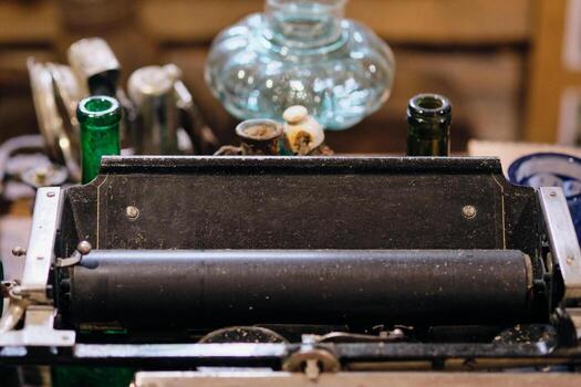 Antique typewriter machine displayed on a table with vintage objects in the background photo