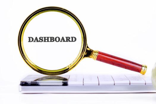 DASHBOARD word showed through the magnifying glass on the calculator. Analyst working with Financial Report and Business Analytics concept photo