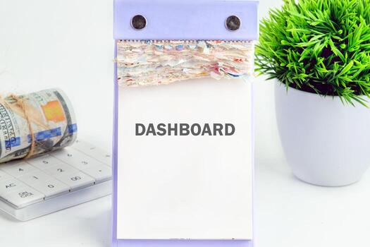 DASHBOARD word written on a desktop calendar on a white background. Analyst working with Financial Report and Business Analytics concept photo