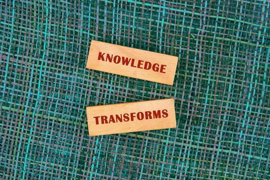 KNOWLEDGE TRANSFORMS concept words made of wooden blocks on fabric background, top view photo