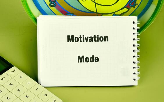 un espiral cuaderno muestra el palabras motivación modo siguiente a un calculadora y vistoso redondo objeto, todas conjunto en un sólido verde antecedentes foto