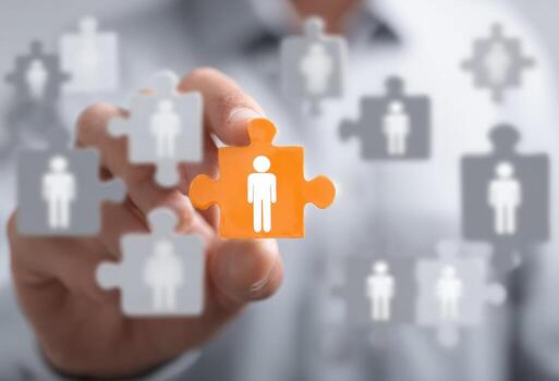 Man holding orange puzzle piece with people on it photo