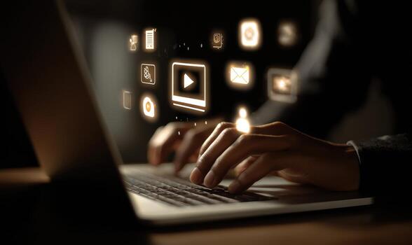 A person typing on a laptop with icons coming out of the screen photo