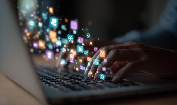 A person is typing on a laptop with icons coming out of the keyboard photo