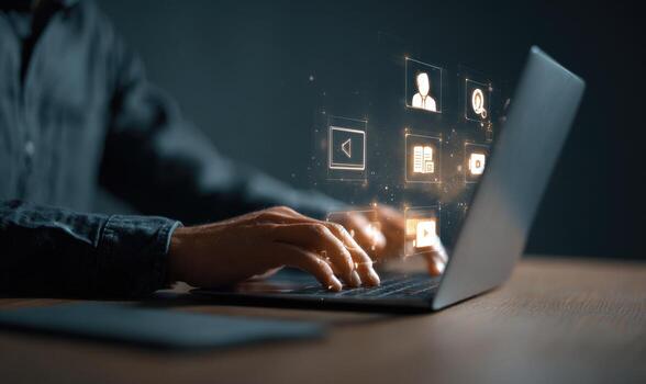 A man using a laptop with icons on the screen photo
