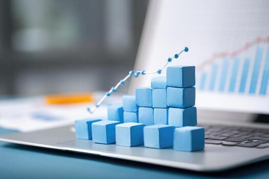 Blue cubes on laptop with graph and bar chart photo