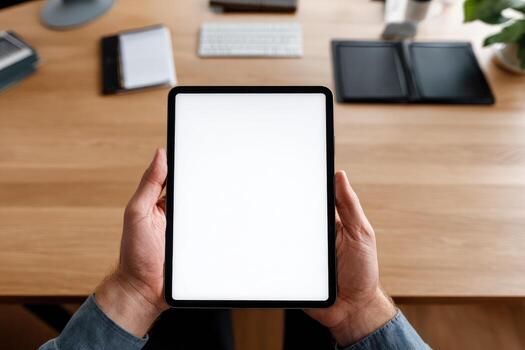 A person holding a tablet with a blank screen photo