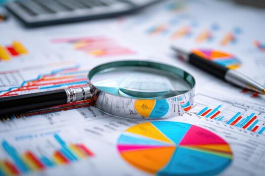 Business charts and financial reports with magnifying glass and pen on table photo