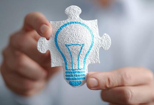 A person holding a puzzle piece with a light bulb on it photo
