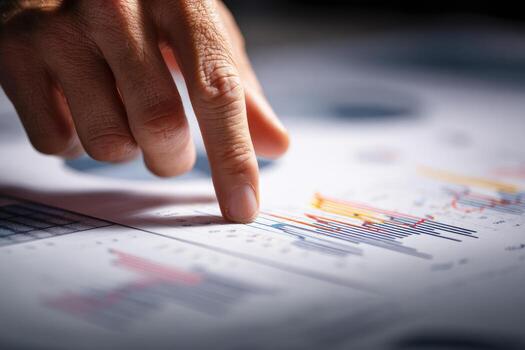 un de la persona dedo es señalando a un grafico en un papel foto