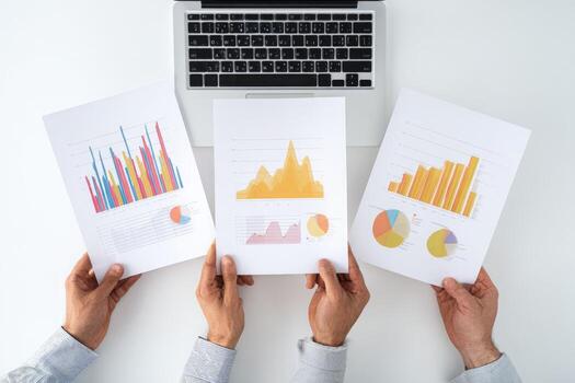 Hands holding papers with graphs and graphs on them photo