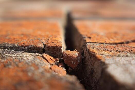 A close up of a brick wall with a crack photo