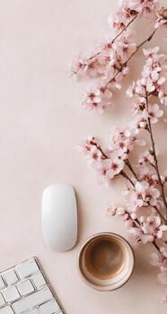 A keyboard, a mouse and a cup of coffee are on a pink background photo