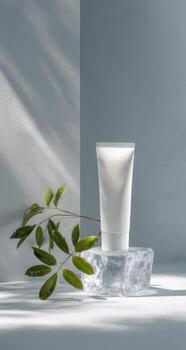 A tube of cream sits on top of an ice block photo