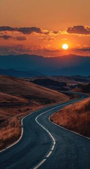 A long winding road with a sunset in the background photo