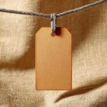 A brown tag hanging from a string on a linen background photo