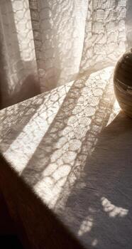 A vase sitting on a table next to a curtain photo