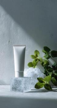 A tube of cream sits on top of a block of ice photo