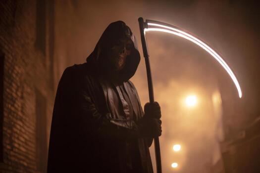 A hooded figure stands in a dimly lit alley, gripping a glowing scythe against a backdrop of fog and old brick buildings, creating an eerie atmosphere at night photo