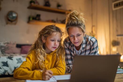 In a cozy study area filled with warm lighting, a parent assists a child with math problems during an online tutoring session photo