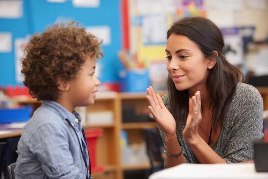 In a lively classroom, a teacher and a young student exchange thoughts enthusiastically, creating an interactive learning atmosphere. The discussion fosters creativity and understanding photo