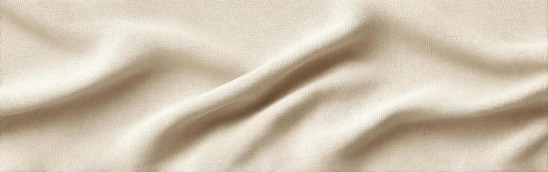 A soft beige fabric lies gracefully on a flat surface, displaying delicate folds and smooth textures. The gentle curves highlight the fabrics quality and warmth photo