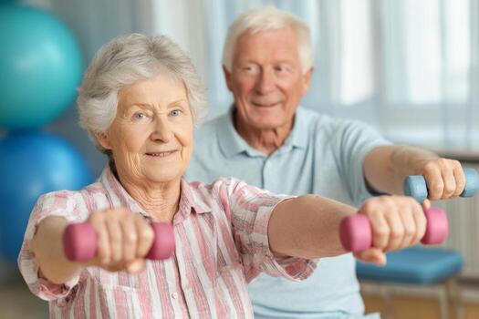 An active elderly couple participates in a fitness class, using colorful dumbbells to enhance their strength and mobility. They smile while engaging in healthy physical activity photo