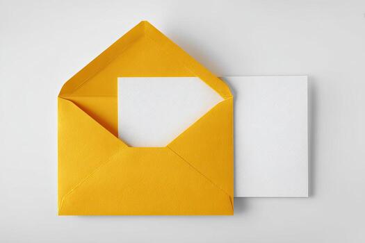 Open yellow envelope revealing a blank white card, another white card rests to the side photo