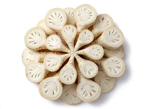 Overhead view of sliced root vegetables arranged in a circular floral pattern on white photo
