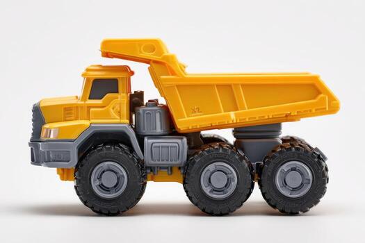 Side view of a small, yellow and gray toy dump truck on a white surface photo