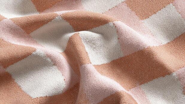 de cerca de un suave, texturizado tela con un melocotón y crema a cuadros modelo. tela es cubierto en pliegues foto